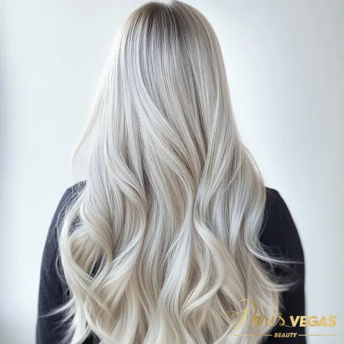 Mulher com cabelo longo exibindo tonalidade ice blonde de costas.