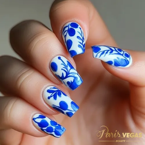 Unhas azul e branco com desenhos florais no salão Paris Vegas Beauty, Moema, São Paulo.