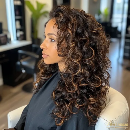 Mulher de lado com cabelo cacheado e mechas no salão de beleza Moema Paris Vegas