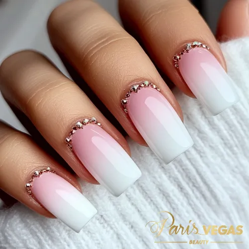 Design ombré em branco e rosa com detalhes de strass, criando um visual delicado e elegante.