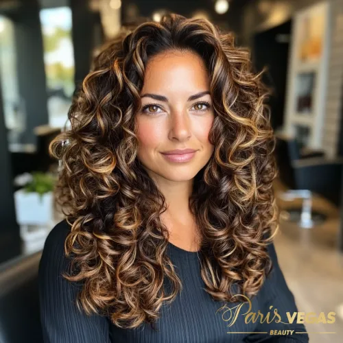 Cabelo cacheado de morena iluminada, exibido de maneira deslumbrante no salão Paris Vegas Beauty em São Paulo.