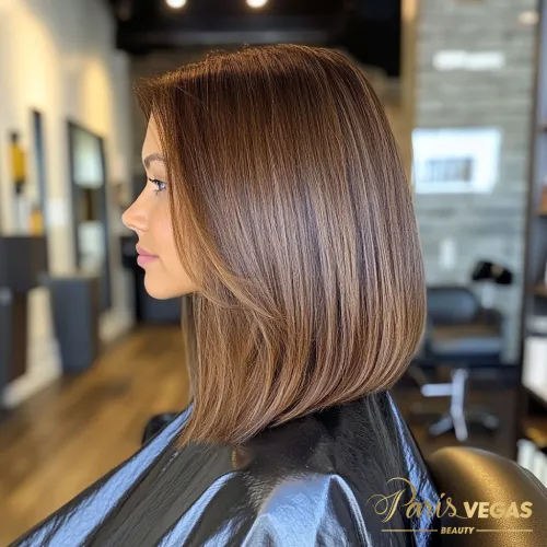 Mulher com cabelo curto em tom de morena iluminada, exibindo um estilo chic e moderno em um ambiente elegante.