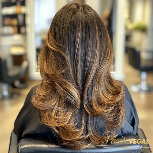 Mulher de costas com cabelo liso e elegante em morena iluminada caramelo.