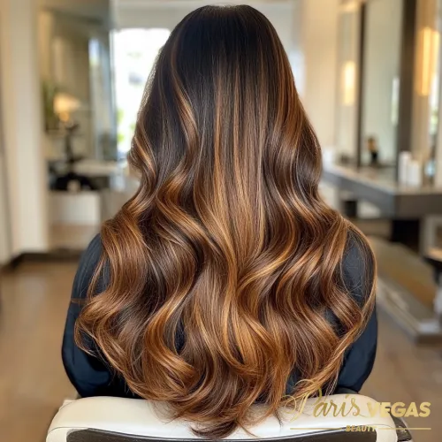 Mulher de costas com estilo morena iluminada caramelo, destacando a beleza do cabelo.