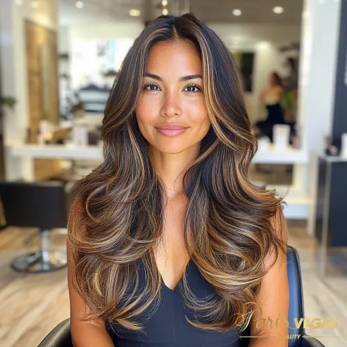 Mulher com cabelo morena iluminada caramelo em salão de luxo.