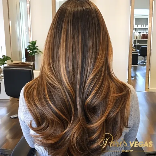 Mulher de costas com cabelo liso em morena iluminada dourado, exibindo charme e sofisticação.