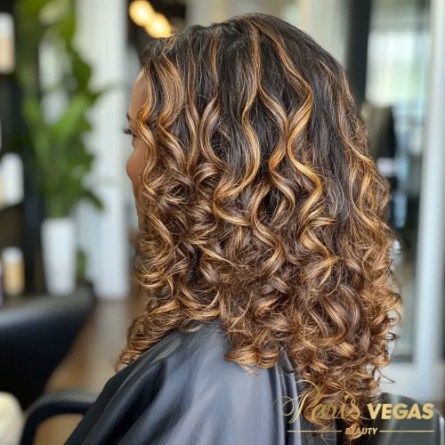 Morena iluminada com cabelo cacheado, posando com confiança no salão Paris Vegas Beauty em São Paulo.