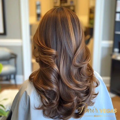 Mulher de costas com cabelo liso em morena iluminada mel e dourado.