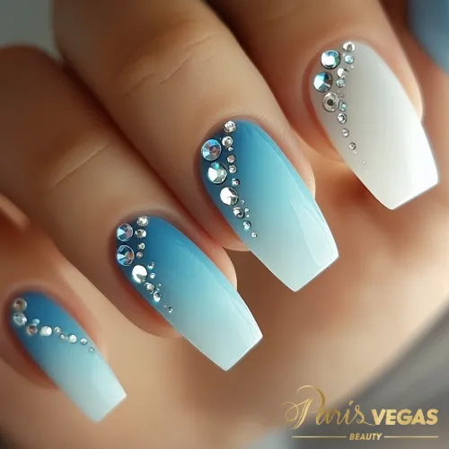 Unhas decorada azul com ombré e strass, criando um design sofisticado e brilhante, perfeito para manicures elegantes em São Paulo.