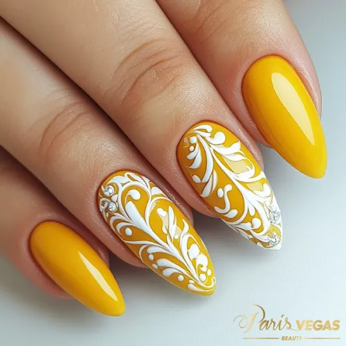 Unhas amarelas decoradas com arabescos, feitas por manicure profissional no salão Paris Vegas Beauty em São Paulo.