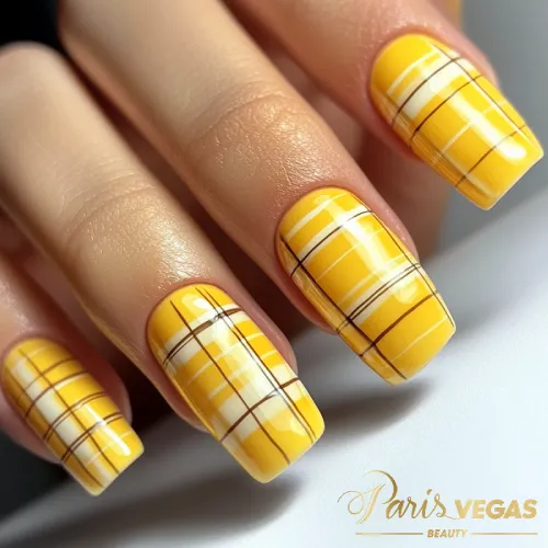 Unhas amarelas com design quadriculado, feitas por nail designer perto de você. Um estilo moderno e criativo para quem busca um visual único.