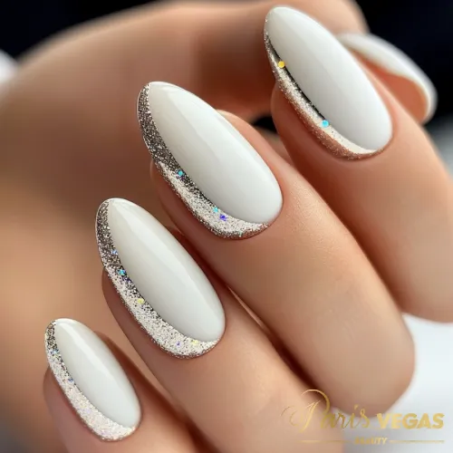 Unhas decoradas branco com glitter nas laterais, criando um efeito sofisticado e moderno.