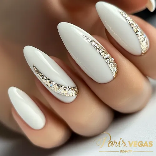 Unhas decoradas branco com detalhes dourados, criando um visual elegante e sofisticado.