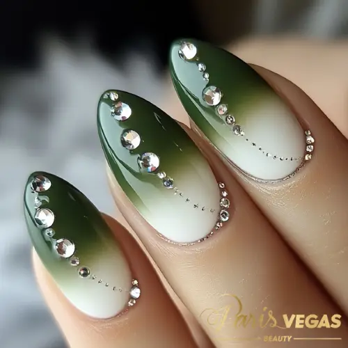 Unhas em verde com efeito ombré e strass, estilo sofisticado e moderno.