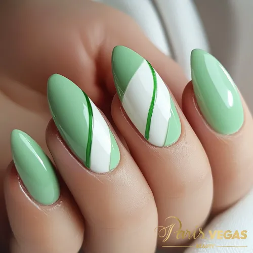 Unhas em verde com curvas brancas, design elegante e sofisticado.