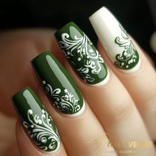 Unhas em verde com arabescos brancos, design delicado e sofisticado.