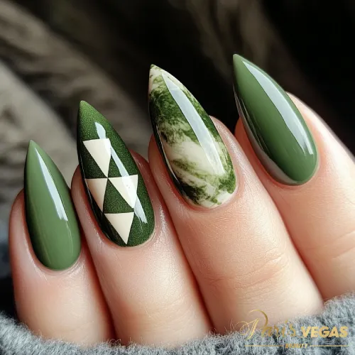 Unhas em verde marmorizadas no formato stiletto, design moderno e ousado.