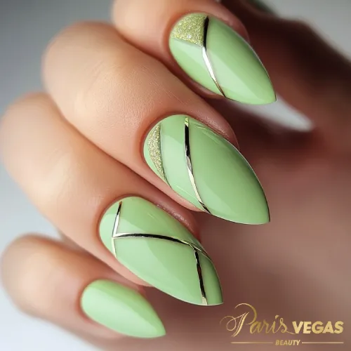 Unhas em verde com detalhes em metais dourados, design sofisticado e luxuoso.