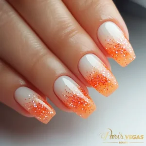 Unhas laranja com efeito ombré glitter, destacando uma técnica moderna de nail art.