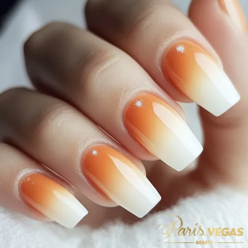 Unhas laranja com efeito babyboomer, destacando um design suave e elegante.