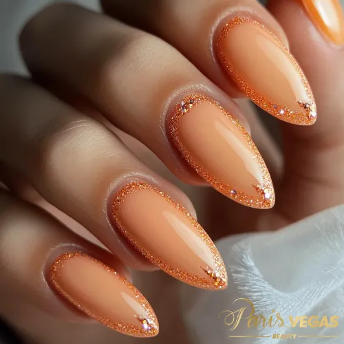 Unhas laranja com efeito pastel e glitter brilho, destacando um design suave e glamouroso.