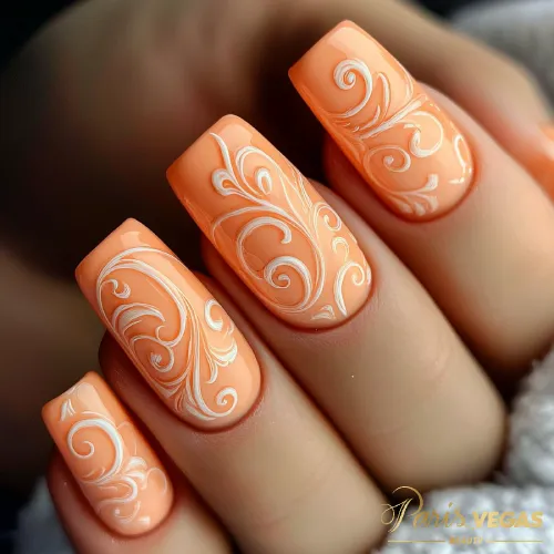 Unhas laranja decoradas com arabescos, destacando um design elegante e artístico.