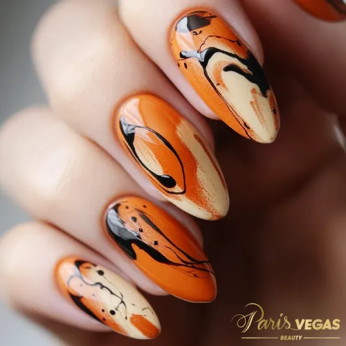 Unhas laranja com design de nail art, destacando um estilo criativo e moderno.