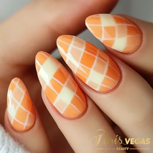 Unhas laranja com design de xadrez, destacando um estilo moderno e divertido.