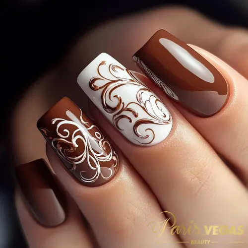 Unhas marrons com arabescos destacados, criando um design elegante e sofisticado.