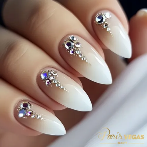 Unhas nude com pedrarias feitas por manicure perto de você.